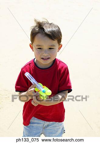 Young boy playing with water gun View Large Photo Image Stock Photography - Young boy playing with water gun. Fotosearch