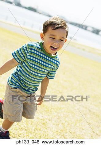 Young boy running and smiling View Large Photo Image Stock Photograph - Young boy running and smiling. Fotosearch