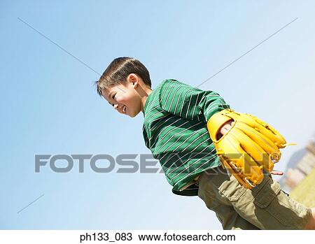 Young boy standing with baseball mitt View Large Photo Image Stock Image - Young boy standing with baseball mitt. Fotosearch