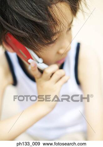 Young boy talking on mobile phone View Large Photo Image Stock Photo - Young boy talking on mobile phone. Fotosearch