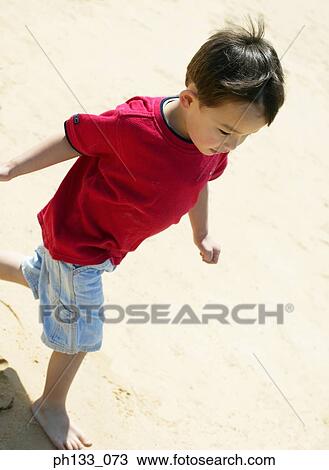 Young boy walking on the beach View Large Photo Image Stock Image - Young boy walking on the beach. Fotosearch