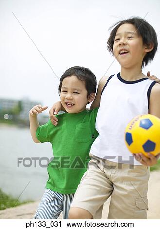Young boys smiling & walking with football View Large Photo Image Stock Image - Young boys smiling & walking with football. Fotosearch