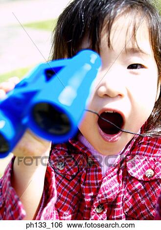 Young girl holding a pair of binoculars View Large Photo Image Stock Photograph - Young girl holding a pair of binoculars. Fotosearch
