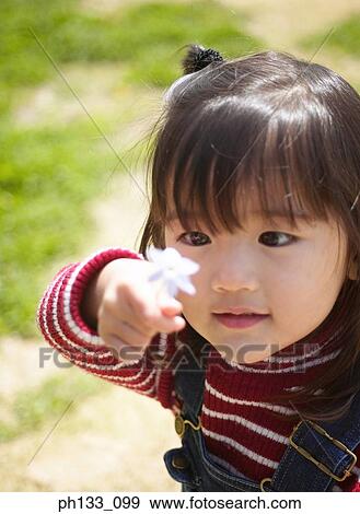 Young girl looking at flower View Large Photo Image Stock Photo - Young girl looking at flower. Fotosearch