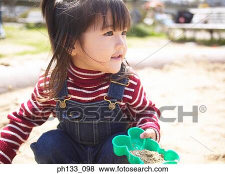 Young girl playing in sandpit View Large Photo Image Stock Photo - Young girl playing in sandpit. Fotosearch