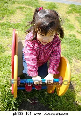 Young girl sitting on rocking horse View Large Photo Image Stock Image - Young girl sitting on rocking horse. Fotosearch