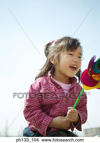 Young girl smiling & playing with toy View Large Photo Image Picture - Young girl smiling & playing with toy. Fotosearch