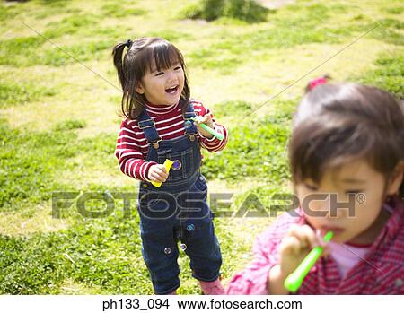 Young girls blowing bubbles View Large Photo Image Picture - Young girls blowing bubbles. Fotosearch