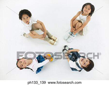 Stock Photo - children sitting on the floor and looking up. Fotosearch