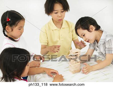 Group of young children playing with wooden building blocks View Large Photo Image Stock Photo - Group of young children playing with wooden building blocks. Fotosearch