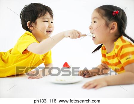 Young boy feeding food to young girl View Large Photo Image Stock Photograph - Young boy feeding food to young girl. Fotosearch
