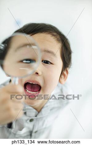 Young boy holding magnifying glass View Large Photo Image Picture - Young boy holding magnifying glass. Fotosearch