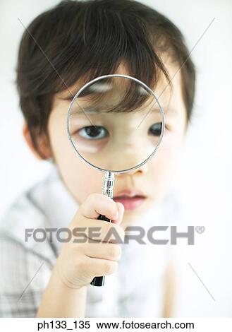 Stock Photography - Young boy holding magnifying glass. Fotosearch
