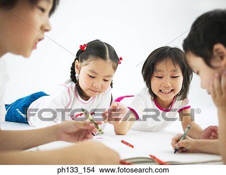 Young children lying on the floor and drawing View Large Photo Image Picture - Young children lying on the floor and drawing. Fotosearch