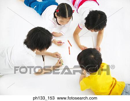 Young children lying on the floor and drawing View Large Photo Image Stock Image - Young children lying on the floor and drawing. Fotosearch