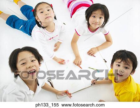 Young children lying on the floor drawing and looking up View Large Photo Image Stock Photography - Young children lying on the floor drawing and looking up. Fotosearch
