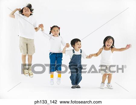Stock Image - Young children smiling & jumping. Fotosearch