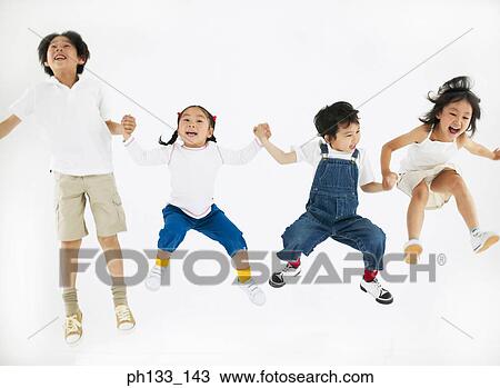 Stock Image - Young children smiling & jumping. Fotosearch