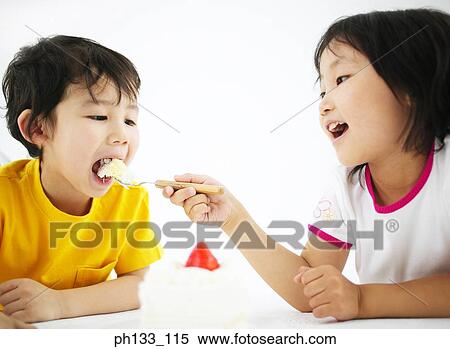 Young girl feeding food to young boy View Large Photo Image Stock Photography - Young girl feeding food to young boy. Fotosearch
