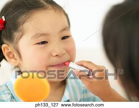 Young girl getting lipstick applied View Large Photo Image Stock Photo - Young girl getting lipstick applied. Fotosearch
