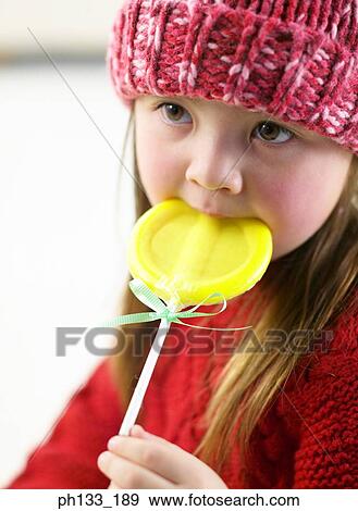 Young girl holding candy View Large Photo Image Stock Photo - Young girl holding candy. Fotosearch