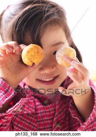 Young girl holding up cookies View Large Photo Image Stock Photo - Young girl holding up cookies. Fotosearch