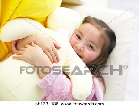 Stock Photograph - Young girl hugging soft toy. Fotosearch