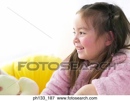 Stock Photo - Young girl sitting and smiling. Fotosearch