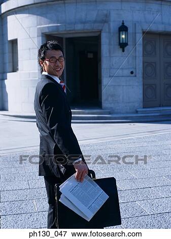 Stock Photo - Asian Man looking over his shoulder. Fotosearch