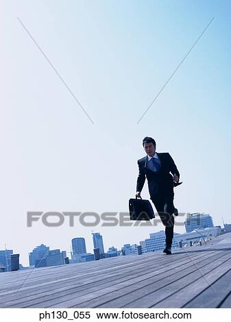 Stock Photography - Asian Man running on a walkway. Fotosearch