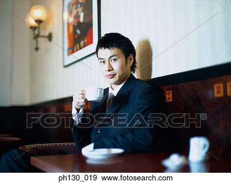 Asian Man sipping tea at a café View Large Photo Image Stock Photo - Asian Man sipping tea at a café. Fotosearch
