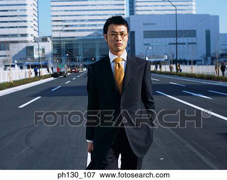Asian Man standing in the middle of the street View Large Photo Image Stock Photo - Asian Man standing in the middle of the street. Fotosearch