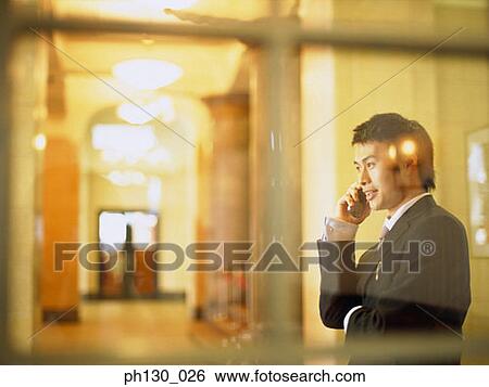 Asian Man talking on a cell phone View Large Photo Image Stock Photograph - Asian Man talking on a cell phone. Fotosearch