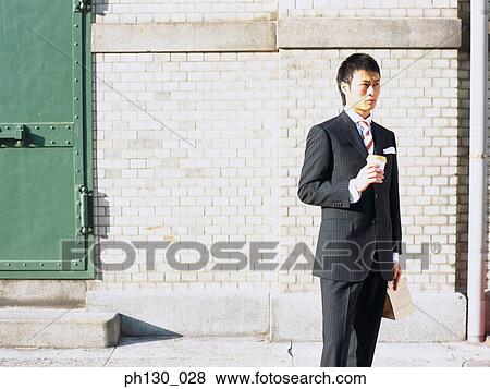 Stock Photo - Asian Man waiting by the street. Fotosearch