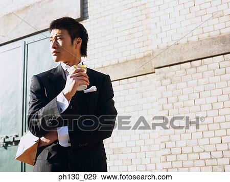 Stock Photo - Asian Man waiting by the street. Fotosearch