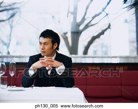 Asian Man waiting in a restaurant View Large Photo Image Stock Photography - Asian Man waiting in a restaurant. Fotosearch