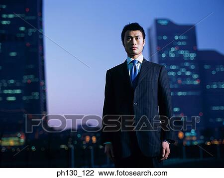 Asian Standing amidst skyscrapers View Large Photo Image Stock Image - Asian Standing amidst skyscrapers. Fotosearch