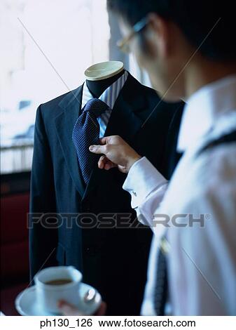 Asian Man checking his tie View Large Photo Image Stock Photograph - Asian Man checking his tie . Fotosearch