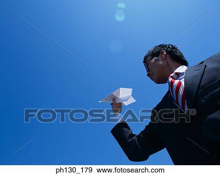 Asian Man holding a paper plane View Large Photo Image Stock Photo - Asian Man holding a paper plane. Fotosearch