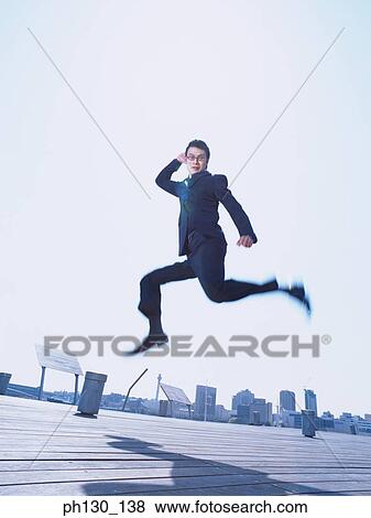 Asian Man jumping on a bridge View Large Photo Image Stock Photo - Asian Man jumping on a bridge. Fotosearch
