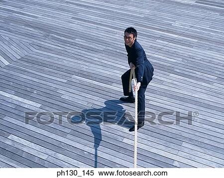 Asian Man pulling at a rope View Large Photo Image Stock Photography - Asian Man pulling at a rope. Fotosearch
