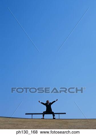 Asian Man sitting on a bench and stretching View Large Photo Image Stock Photo - Asian Man sitting on a bench and stretching. Fotosearch