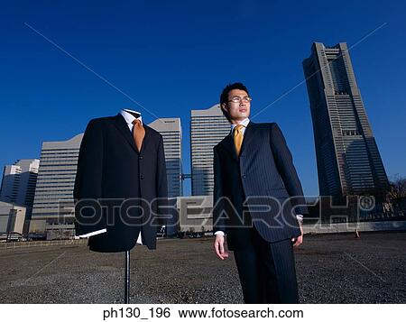 Asian Man standing in a lot with a mannequin View Large Photo Image Stock Photograph - Asian Man standing in a lot with a mannequin. Fotosearch