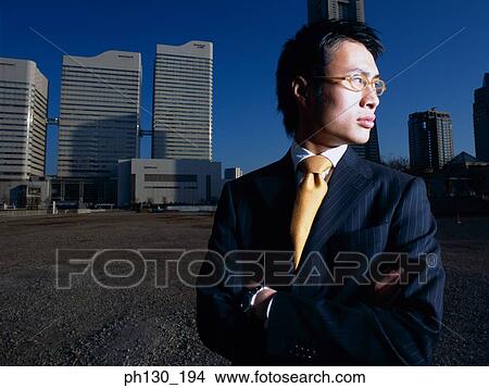 Asian Man standing in an empty parking lot View Large Photo Image Picture - Asian Man standing in an empty parking lot. Fotosearch
