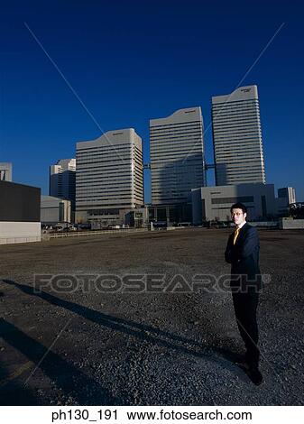Asian Man standing in an empty parking lot View Large Photo Image Stock Image - Asian Man standing in an empty parking lot. Fotosearch