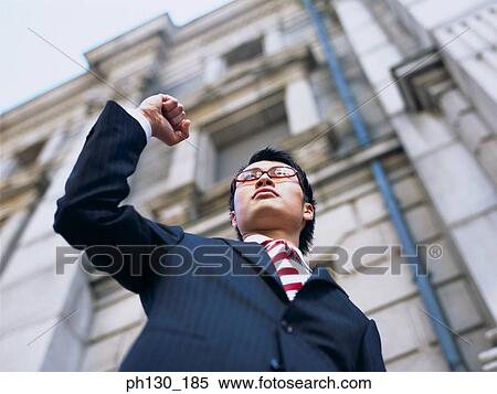 Asian Man standing on a ledge View Large Photo Image Stock Photography - Asian Man standing on a ledge. Fotosearch