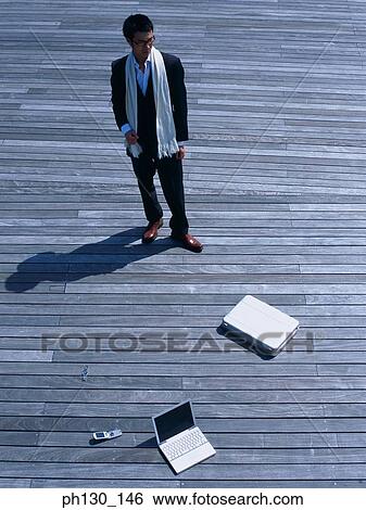 Asian Man with business accessories on a bridge View Large Photo Image Stock Photograph - Asian Man with business accessories on a bridge. Fotosearch