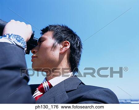 Stock Photograph - Man looking through binoculars. Fotosearch