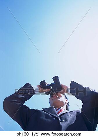 Man looking through binoculars View Large Photo Image Stock Photography - Man looking through binoculars. Fotosearch
