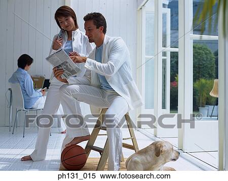 Stock Photography - A couple discussing the newspaper. Fotosearch